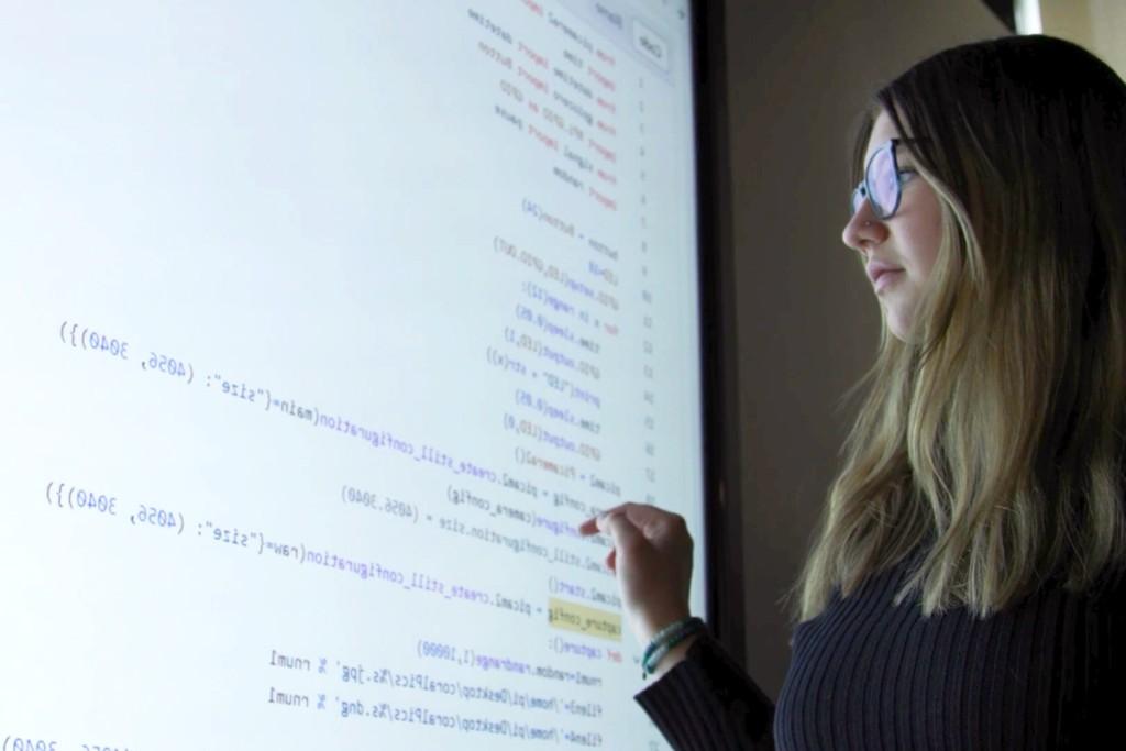 一名计算机科学专业的学生在大屏幕上查看计算机代码